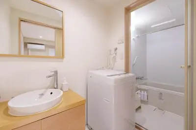 a white bathroom with a sink and a mirror at \u697d\u9038\u30b0\u30eb\u30fc\u30d7 \u6c60\u888b\u745e\u6708\u82d11F 111Ta in Tokyo