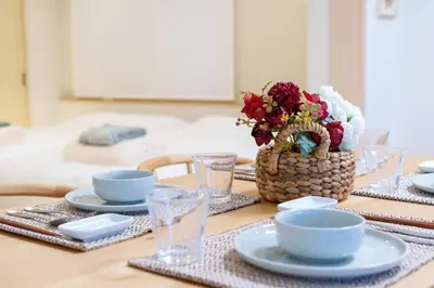 a table with plates and bowls and a basket of flowers at \u697d\u9038\u30b0\u30eb\u30fc\u30d7 \u6c60\u888b\u745e\u6708\u82d11F 111Ta in Tokyo