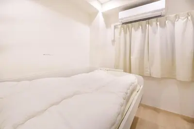 a white bed in a white room with a window at \u697d\u9038\u30b0\u30eb\u30fc\u30d7 \u6c60\u888b\u745e\u6708\u82d12F 111Tb in Tokyo