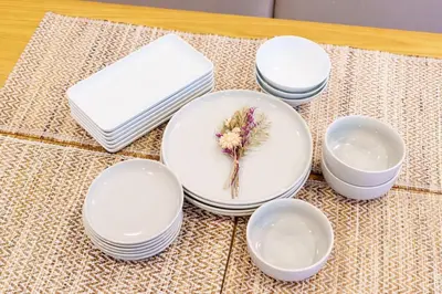 a group of white plates with a flower on them at \u697d\u9038\u30b0\u30eb\u30fc\u30d7 \u6c60\u888b\u745e\u6708\u82d12F 111Tb in Tokyo