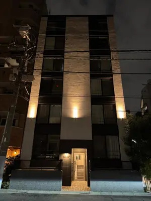 a building with a door in front of it at night at T r u s t V a l u e Kuramae in Tokyo