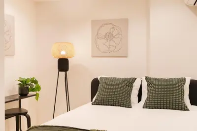 a bedroom with a white bed with green pillows at T r u s t V a l u e Kuramae in Tokyo