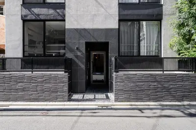 a building with a black door in the middle at T r u s t V a l u e Kuramae in Tokyo