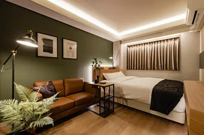 a bedroom with a bed and a couch at Hotel The Loop in Tokyo