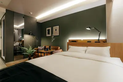 a bedroom with a white bed and a green wall at Hotel The Loop in Tokyo