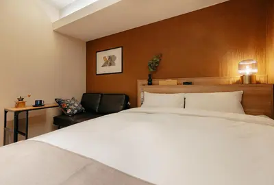 a bedroom with a large white bed and a chair at Hotel The Loop in Tokyo