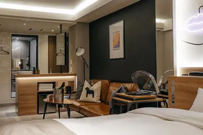a bedroom with a bed and a living room at Hotel The Loop in Tokyo