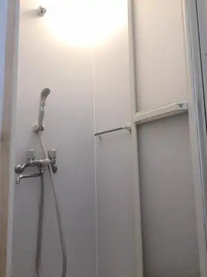 a shower in a bathroom with a light on the wall at Shinjuku 105 in Tokyo
