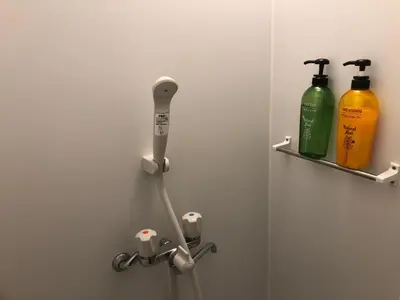 a bathroom with a dispenser and two bottles on a wall at Shinjuku 105 in Tokyo