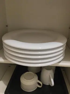 a stack of white plates sitting on a shelf at Shinjuku 105 in Tokyo