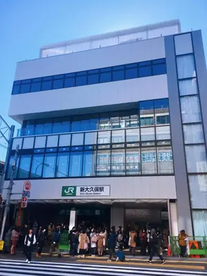 a group of people walking in front of a building at Shinjuku 105 in Tokyo