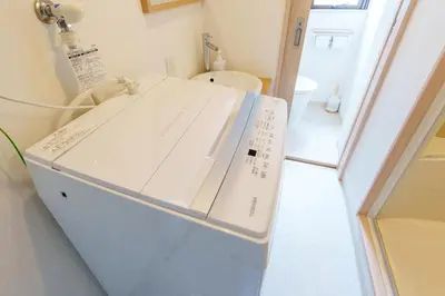 a kitchen with a white refrigerator in a room at \u697d\u9038\u30b0\u30eb\u30fc\u30d7 \u6c60\u888b\u745e\u6708\u82d13F 111Tc in Tokyo