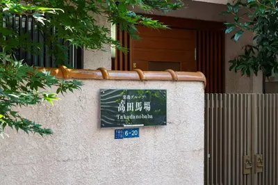 a sign on a wall in front of a building at \u697d\u9038\u30b0\u30eb\u30fc\u30d7 \u9ad8\u7530\u99ac\u5834 114t in Tokyo