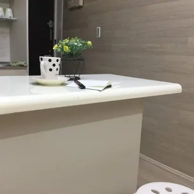 a table with a book and a vase with flowers on it at Shinjuku 102 in Tokyo