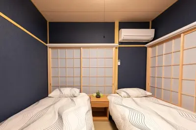 a room with two beds and a heater in it at Y's INN MaisonRose 106T in Tokyo