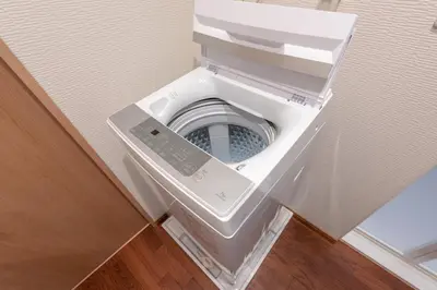 a washing machine in a room with its door open at Y's INN MaisonRose 106T in Tokyo