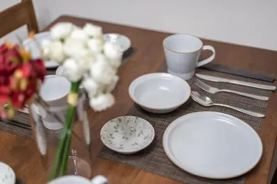 a table with plates and cups and flowers on it at Y's INN MaisonRose 106T in Tokyo