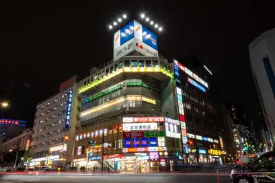 a tall building with lights on it at night at Y's INN MaisonRose 106T in Tokyo