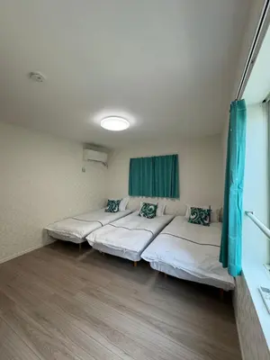 a room with three beds and a window in it at Asakusa\u5708\u99c5\u304b\u30898\u5206\u65e5\u5f0f\u72ec\u680b\u522b\u5885 in Tokyo