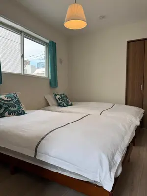 a bedroom with two large beds with a window at Asakusa\u5708\u99c5\u304b\u30898\u5206\u65e5\u5f0f\u72ec\u680b\u522b\u5885 in Tokyo