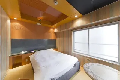 a small bedroom with a bed and a window at International Hotel Kabukicho in Tokyo