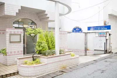 a building with plants on the side of a street at Shinjuku East Hotel in Tokyo