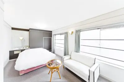 a bedroom with a white bed and a couch at Shinjuku East Hotel in Tokyo