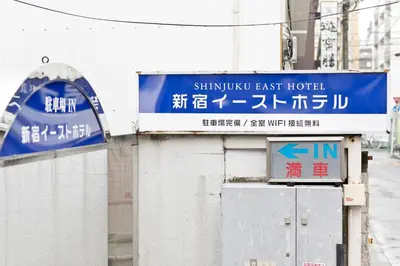 a sign for a shinkansen east hotel on a street at Shinjuku East Hotel in Tokyo