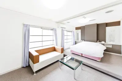 a bedroom with a bed and a chair and a table at Shinjuku East Hotel in Tokyo