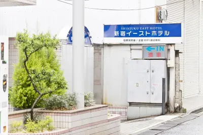 a building with a blue sign on the side of it at Shinjuku East Hotel in Tokyo