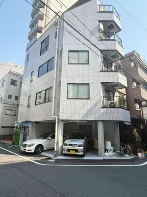 two cars parked in front of a building at \u677e\u5c4b Hotel in Tokyo