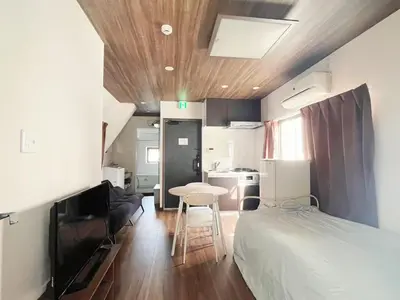 a bedroom with a bed and a table and a kitchen at \u677e\u5c4b Hotel in Tokyo