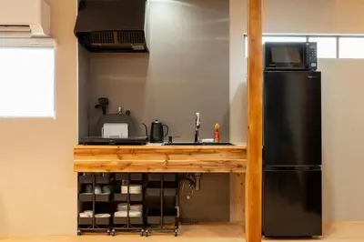 a kitchen with a sink and a refrigerator at \u51ea\u30ce\u5bb6\u66f3\u821f Naginoya Hikihune in Tokyo