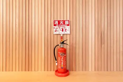 a red fire hydrant with two signs on it at \u51ea\u30ce\u5bb6\u66f3\u821f Naginoya Hikihune in Tokyo