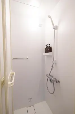 a shower in a bathroom with a white wall at Tokyo Ninja \u5c4b\u6577 in Tokyo