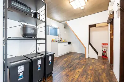a room with three trash cans and a kitchen at Tokyo Ninja \u5c4b\u6577 in Tokyo