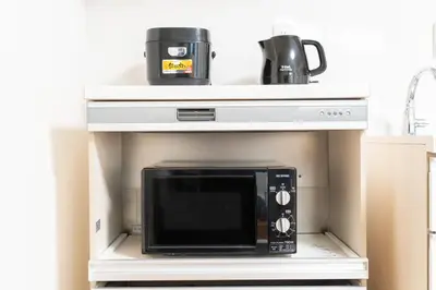 a microwave on a shelf in a kitchen at \u6c60\u888b\u65b0\u5bbf\u30a8\u30ea\u30a2 \u5927\u585a\u99c5\u8fd1 \u5546\u5e97\u8857\u5f92\u6b69\u570f\u5185 \u8cb8\u5207\u4e00\u6238\u5efa 2\u90e8\u5c4b \u6700\u59275\u540d\u5bbf\u6cca\u53ef in Tokyo