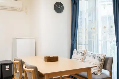 a dining room table with chairs and a clock on the wall at \u6c60\u888b\u65b0\u5bbf\u30a8\u30ea\u30a2 \u5927\u585a\u99c5\u8fd1 \u5546\u5e97\u8857\u5f92\u6b69\u570f\u5185 \u8cb8\u5207\u4e00\u6238\u5efa 2\u90e8\u5c4b \u6700\u59275\u540d\u5bbf\u6cca\u53ef in Tokyo