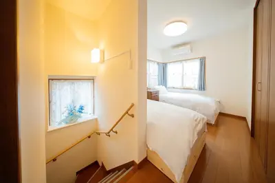 a bedroom with two beds and a window at \u6c60\u888b\u65b0\u5bbf\u30a8\u30ea\u30a2 \u5927\u585a\u99c5\u8fd1 \u5546\u5e97\u8857\u5f92\u6b69\u570f\u5185 \u8cb8\u5207\u4e00\u6238\u5efa 2\u90e8\u5c4b \u6700\u59275\u540d\u5bbf\u6cca\u53ef in Tokyo