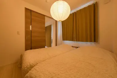 a bedroom with two beds and a chandelier at House Hotel EKODA 2F HE2122 in Tokyo