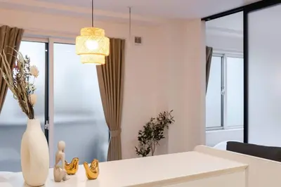 a living room with a white table and a chandelier at House Hotel EKODA 2F HE2122 in Tokyo