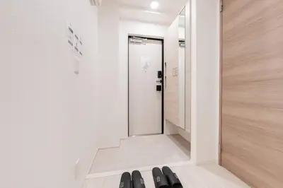 a room with a door and a row of black shoes at House Hotel EKODA 2F HE2122 in Tokyo