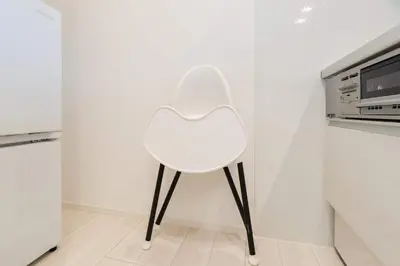 a white chair in a kitchen next to a microwave at House hotel EKODA 1F 3F HE1131 in Tokyo