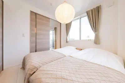 a bedroom with two beds and a chandelier at House hotel EKODA 1F 3F HE1131 in Tokyo