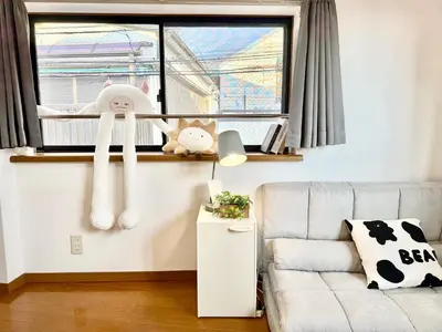 a living room with a couch and a window at Shinjuku Terasu BA in Tokyo
