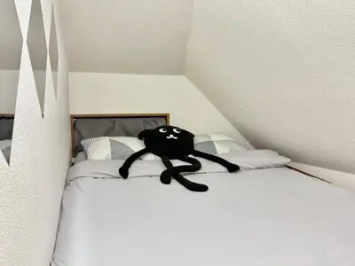a black stuffed animal sitting on top of a bed at Shinjuku Terasu BA in Tokyo