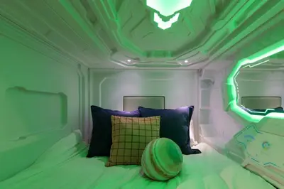 a small bedroom with a bed with a green lighting at SPACESHIP UNIT1 122Ta in Tokyo