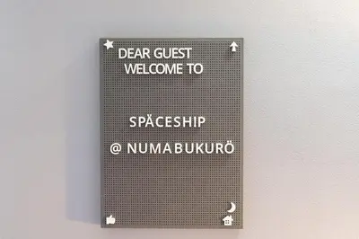 a sign on a wall that says dear guest welcome to spaceships and nuna at SPACESHIP UNIT1 122Ta in Tokyo
