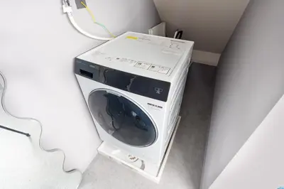 a washing machine sitting in a corner of a room at SPACESHIP UNIT1 122Ta in Tokyo