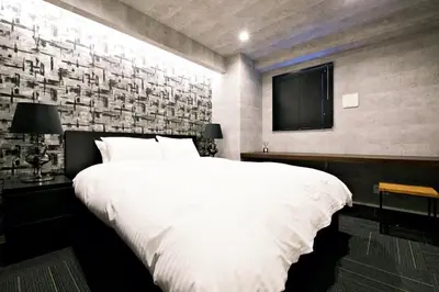 a bedroom with a large white bed and a brick wall at Regalo Shibaura 501 - Vacation STAY 06260v in Tokyo